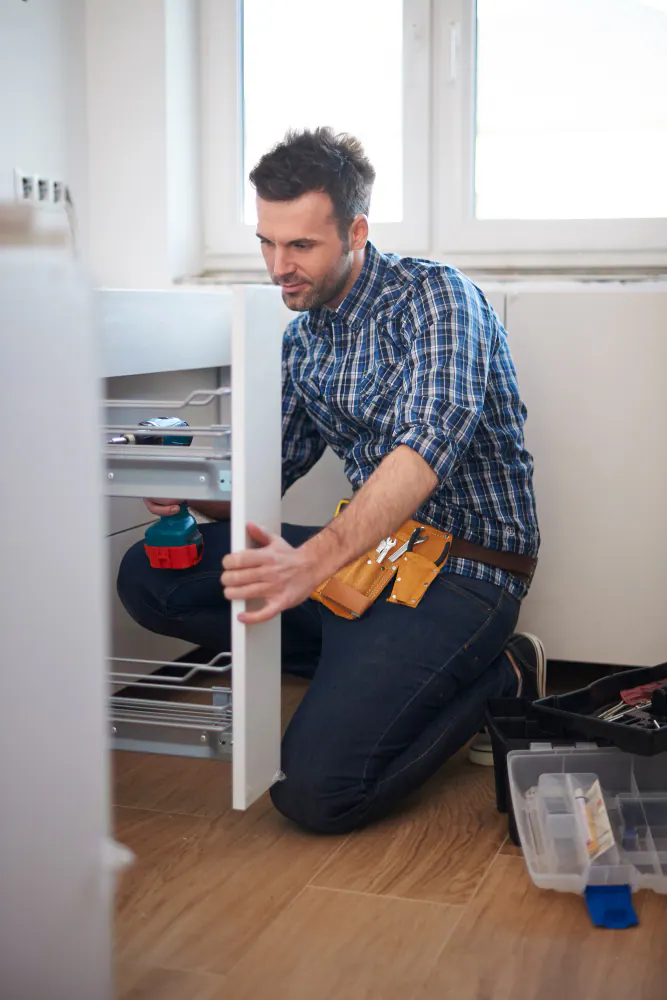 A cabinetmaker fitting a pull-out drawer