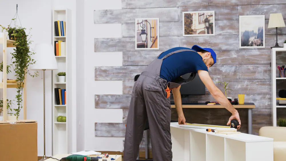 An installer measuring a cabinet run with a tape